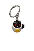 Black cat keychain with red eyes and yellow paw on a white background