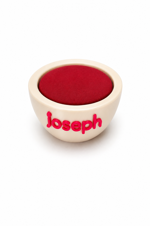Small white bowl with red interior and 'Joseph' branding on a white background