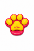 Pink and yellow paw-shaped toy with 'LOLA' on a white background